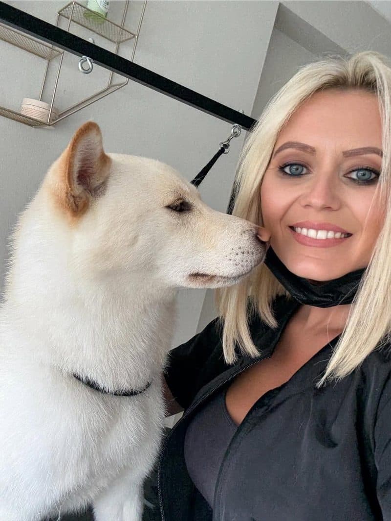 Michelle Adams of The Grooming Boutique mid-groom with a dog